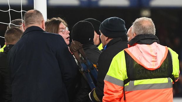 LIVERPOOL, ENGLAND - MARCH 17: Stewards attempt to cut cable ties with bolt cutters after a fan ties himself to the net in protest during the Premier League match between Everton and Newcastle United at Goodison Park on March 17, 2022 in Liverpool, England. (Photo by Michael Regan/Getty Images)