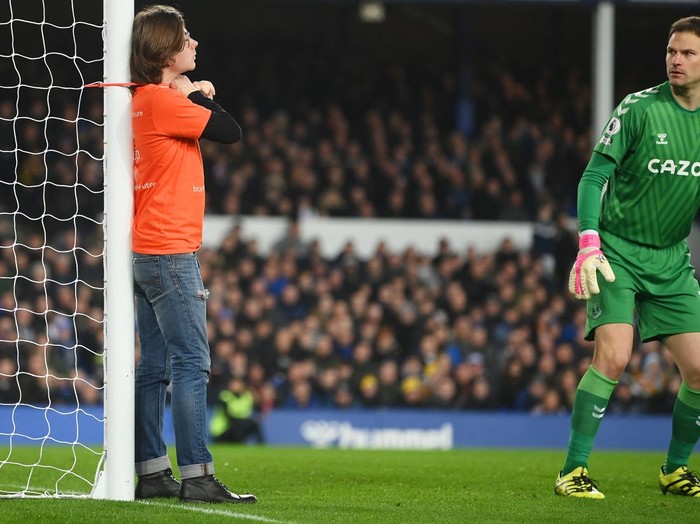LIVERPOOL, ENGLAND - MARCH 17: Asmir Begovic of Everton looks on as a fan ties himself to the net in protest during the Premier League match between Everton and Newcastle United at Goodison Park on March 17, 2022 in Liverpool, England. (Photo by Michael Regan/Getty Images)