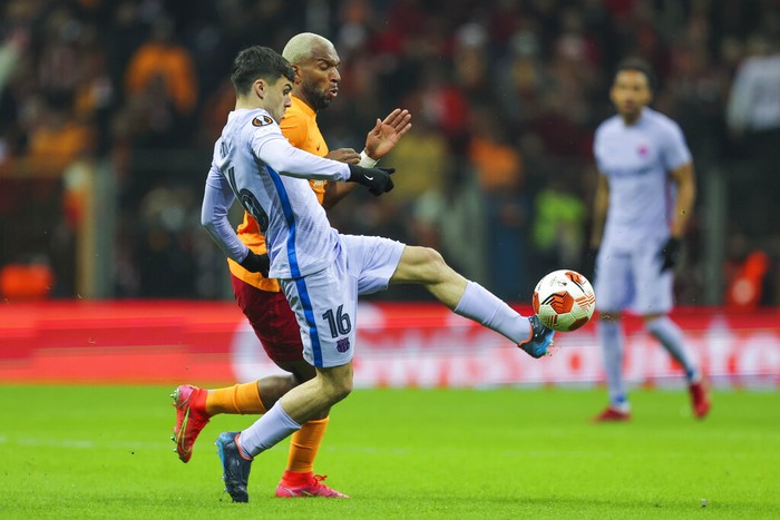Barcelonas Pedri, left, vies for the ball with Galatasarays Ryan Babel during the Europa League round of 16 second leg soccer match between Galatasaray and Barcelona in Istanbul, Turkey, Thursday, March 17, 2022. (AP Photo)