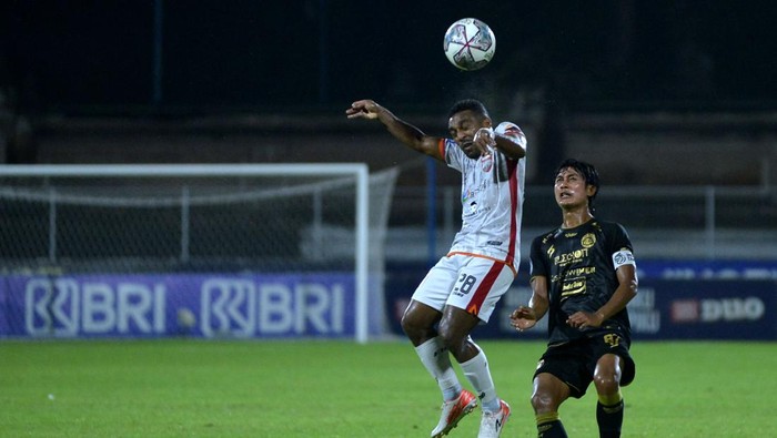 Pesepak bola Arema FC Johan Farizi (kanan) berebut bola dengan pesepak bola Borneo FC Terens Puhiri (kiri) saat pertandingan Liga 1 di Stadion I Gusti Ngurah Rai, Denpasar, Bali, Minggu (20/3/2022). ANTARA FOTO/Fikri Yusuf/foc.