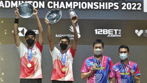 Indonesia's Muhammad Shohibul Fikri, second left, and Bagas Maulana, left, celebrate with their trophies after defeating their compatriots Mohammad Ahsan, right, and Hendra Setiawan during their men's doubles final match at the All England Open Badminton Championships in Birmingham, England, Sunday, March 20, 2022. (AP Photo/Rui Vieira)