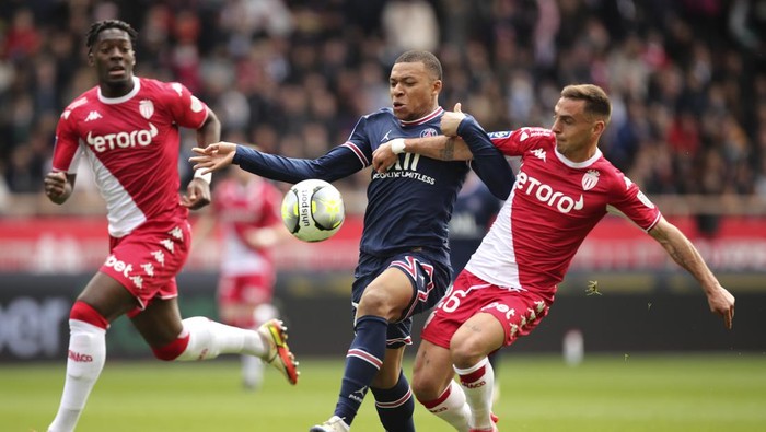 PSGs Kylian Mbappe, center, and Monacos Ruben Aguilar vie for the ball during the French League One soccer match between Monaco and Paris Saint-Germain at the Stade Louis II in Monaco, Sunday, March 20, 2022. (AP Photo/Daniel Cole)