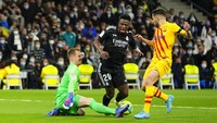 Penjaga gawang Barcelona Marc-Andre ter Stegen, kiri, melakukan penyelamatan di depan Vinicius Junior Real Madrid, tengah.