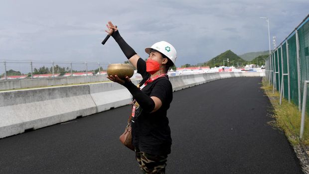 A woman conducts a traditional ritual for good weather during a practice session for the Indonesian Grand Prix MotoGP at the Mandalika International Circuit at Kuta Mandalika in Central Lombok on March 18, 2022. (Photo by SONNY TUMBELAKA / AFP)