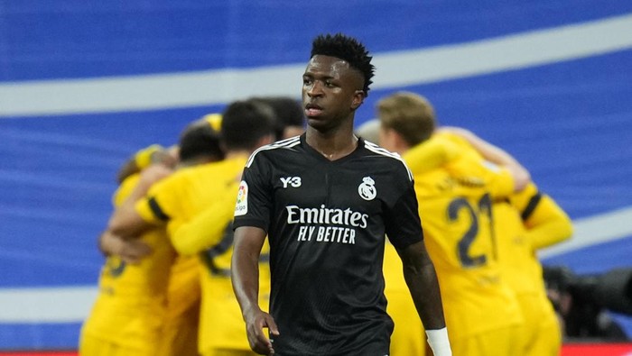 Real Madrids Vinicius Junior gestures as Barcelona players celebrates their first goal by their teammate Pierre-Emerick Aubameyang during a Spanish La Liga soccer match between Rial Madrid and FC Barcelona at the Santiago Bernabeu stadium in Madrid, Spain, Sunday, March 20, 2022. (AP Photo/Manu Fernandez)