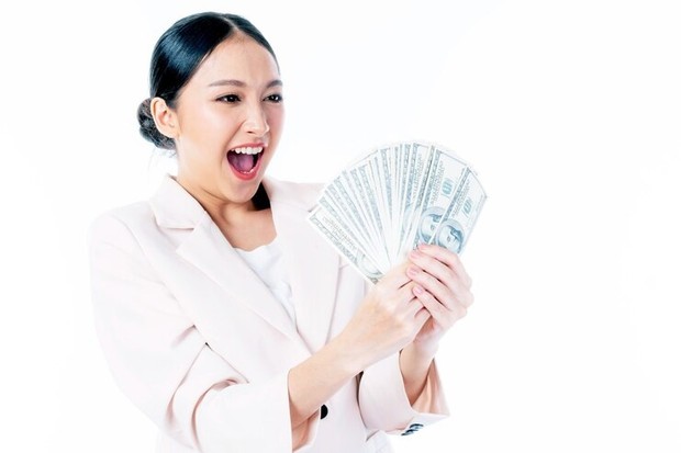 Ilustrasi memegang banyak uang/ Foto: Freepik.com/Suphaporn