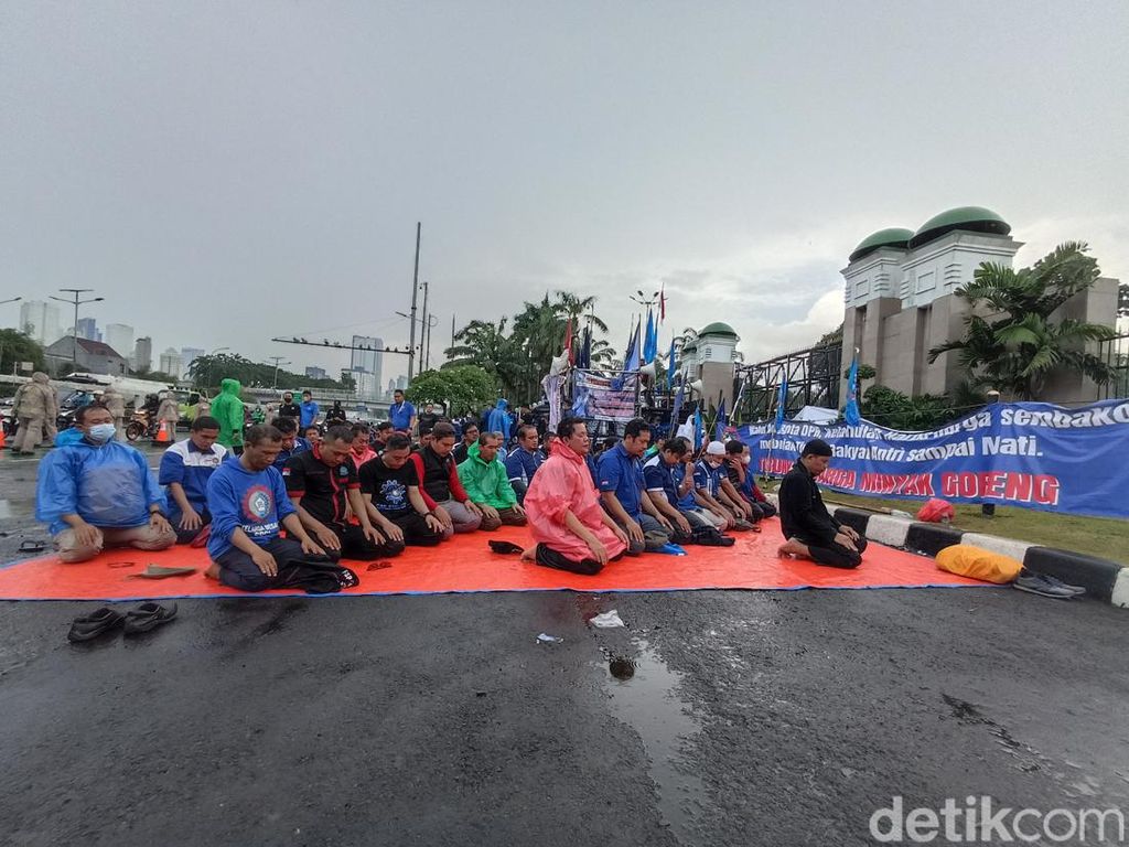 Buruh Demo di DPR Gelar Salat Zuhur Berjemaah di Tengah Guyuran Hujan