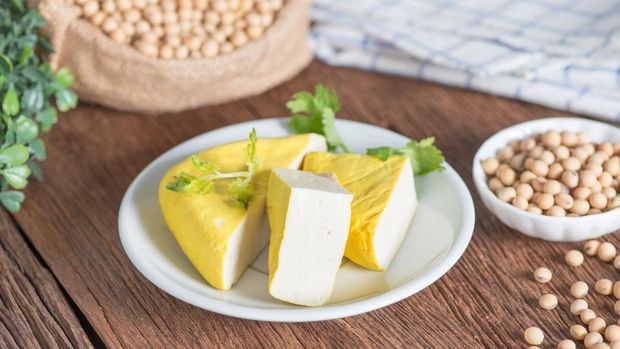 Yellow tofu sliced on plate with soy bean.