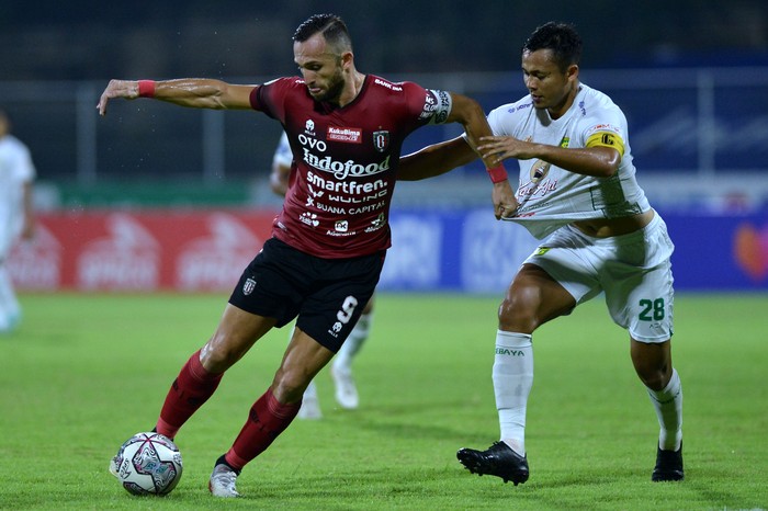 Pesepak bola Bali United Ilija Spasojevic (kiri) berebut bola dengan pesepak bola Persebaya Surabaya Arif Satria (kanan) saat pertandingan Liga 1 di Stadion I Gusti Ngurah Rai, Denpasar, Bali, Jumat (25/3/2022). ANTARA FOTO/Fikri Yusuf/rwa.