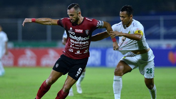 Pesepak bola Bali United Ilija Spasojevic (kiri) berebut bola dengan pesepak bola Persebaya Surabaya Arif Satria (kanan) saat pertandingan Liga 1 di Stadion I Gusti Ngurah Rai, Denpasar, Bali, Jumat (25/3/2022). ANTARA FOTO/Fikri Yusuf/rwa.