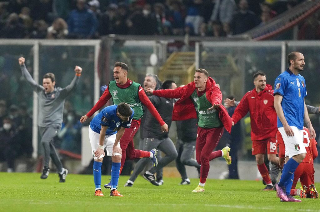 North Macedonia players celebrate as Italy's Alessandro Bastoni reacts after his team's got eliminated at the end of the World Cup qualifying play-off soccer match between Italy and North Macedonia, at Renzo Barbera stadium, in Palermo, Italy, Thursday, March 24, 2022. North Macedonia won 1-0. (AP Photo/Antonio Calanni)