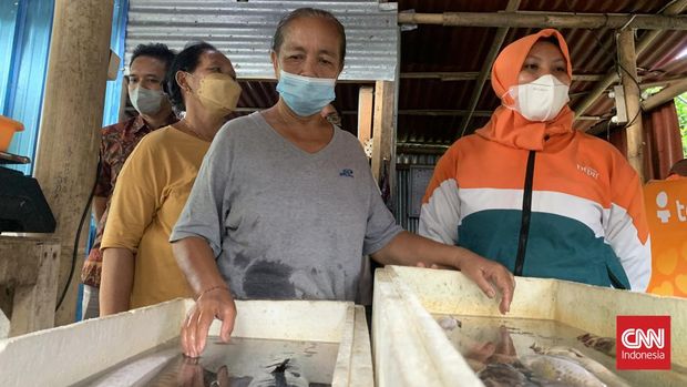 Endang dan Desak, kakak beradik warga Bali, nasabah pembiayaan ultra mikro BTPN Syariah saat menunjukkan usahanya menjual ikan laut segar didampingi Direktur BTPN Syariah Fachmy Achmad di Dalung, Badung, Kuta Utara, Jumat (25/3).