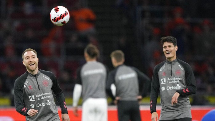 CORRECTS DATE: Denmark's Christian Eriksen, left, reacts as he warms up ahead of the international friendly soccer match between the Netherlands and Denmark at the Johan Cruyff ArenA in Amsterdam, Netherlands, Saturday, March 26, 2022. (AP Photo/Peter Dejong)