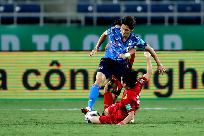 HANOI, VIETNAM - NOVEMBER 11: Japans Yuya Osako (L) fights for the ball with Vietnams Nguyen Tuan Anh (R) during the FIFA World Cup Asian Qualifier final round Group B match between Vietnam and Japan at My Dinh National stadium on November 11, 2021 in Hanoi, Vietnam. (Photo by Minh Hoang/Getty Images)