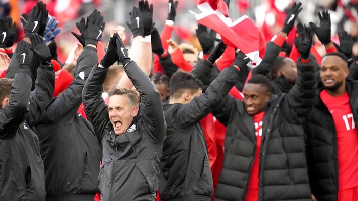 Usai 36 Tahun, Kanada Lolos ke Piala Dunia Lagi Fans cheer and wave Canadian flags before a Canada against Jamaica CONCACAF World Cup soccer qualifying match in Toronto, Sunday, March 27, 2022. (Nathan Denette/The Canadian Press via AP)