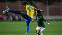 Pemain Brasil Alex Telles menghalau bola saat pemain Bolivia Henry Vaca mengejarnya.