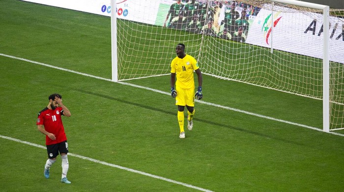 Egypts Mohamed Salah, left, reacts after failing to score his penalty kick against Senegals goalkeeper Edouard Mendy during the World Cup 2022 - Africa playoff soccer match between Senegal and Egypt at at Stade Me Abdoulaye Wade stadium in Dakar, Senegal, Tuesday, March 29, 2022. (AP Photo/Stefan Kleinowitz)