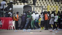 Para pemain Ghana masuk terowongan dari lapangan menuju ruang ganti di tengah situasi ricuh. Foto: AP/Sunday Alamba