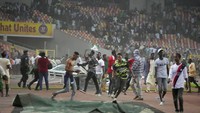 Serbuan suporter Nigeria ke dalam lapangan Moshood Abiola National Stadium membuat polisi juga harus turun tangan. Foto: AP/Sunday Alamba