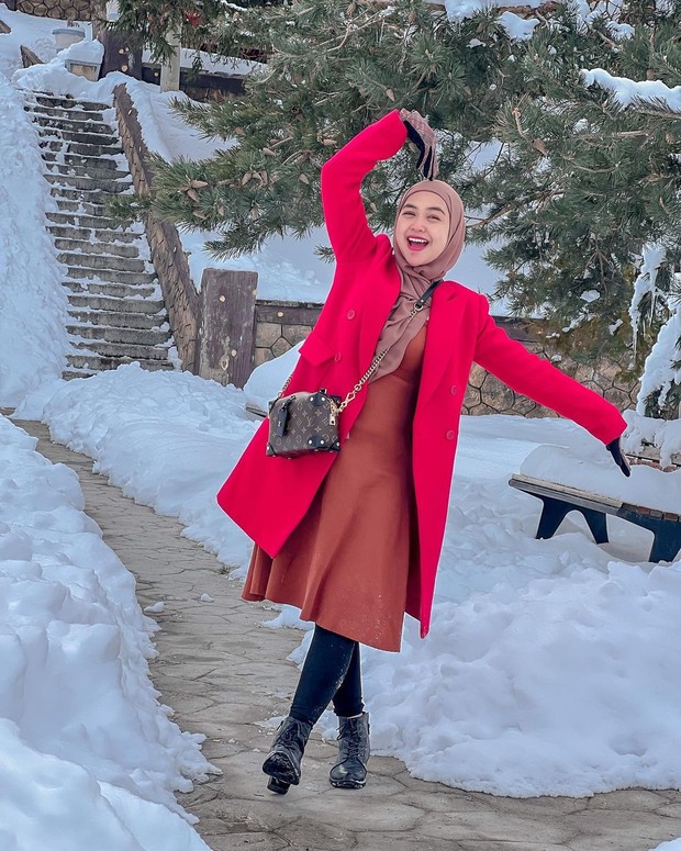 Ria Ricis mengenakan coat dan dress potongan 7/8 saat di luar negeri.