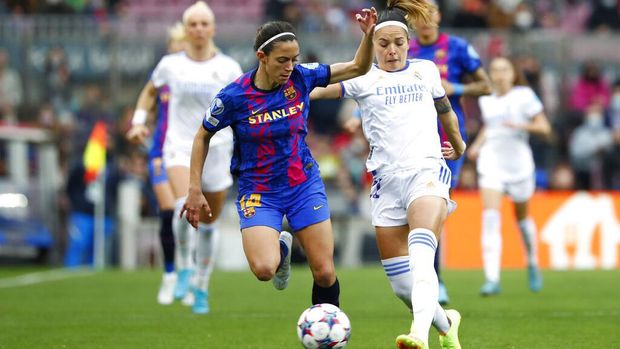 Barcelona's Aitana Bonmatí, left, and Real Madrid's Athenea del Castillo fight for the ball during the Women's Champions League quarter final, second leg soccer match between Barcelona and Real Madrid at Camp Nou stadium in Barcelona, Spain, Wednesday, March 30, 2022. (AP Photo/Joan Monfort)