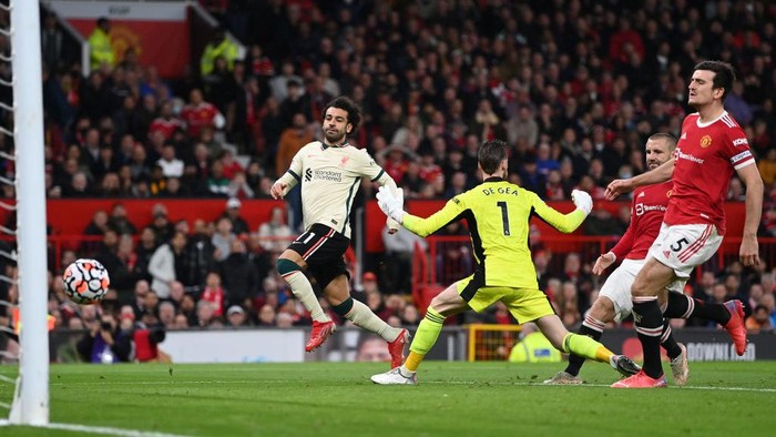 MANCHESTER, ENGLAND - OCTOBER 24:  Mohamed Salah of Liverpool shoots past Manchester United goalkeeper David De Gea to score his hat trick as Harry Maguire and Luke Shaw look on during the Premier League match between Manchester United and Liverpool at Old Trafford on October 24, 2021 in Manchester, England. (Photo by Shaun Botterill/Getty Images)