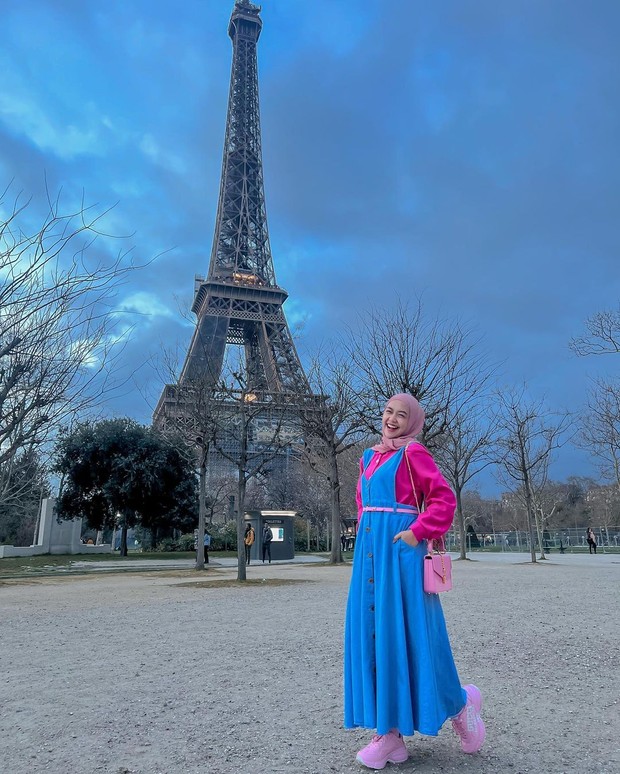 Gaya Ria Ricis yang memerkan baby thumb dengan mengenakna outfit colorful.