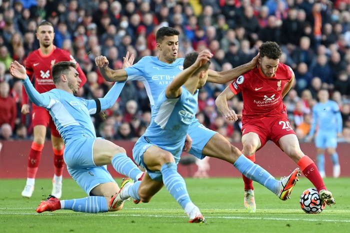LIVERPOOL, ENGLAND - OCTOBER 03: Diogo Jota of Liverpool cuts back whilst under pressure from Aymeric Laporte, Ruben Dias and Joao Cancelo of Manchester City during the Premier League match between Liverpool and Manchester City at Anfield on October 03, 2021 in Liverpool, England. (Photo by Michael Regan/Getty Images)