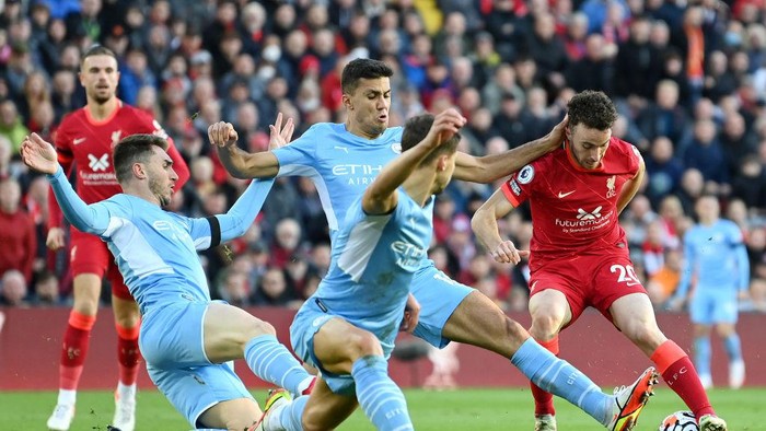 LIVERPOOL, ENGLAND - OCTOBER 03: Diogo Jota of Liverpool cuts back whilst under pressure from Aymeric Laporte, Ruben Dias and Joao Cancelo of Manchester City during the Premier League match between Liverpool and Manchester City at Anfield on October 03, 2021 in Liverpool, England. (Photo by Michael Regan/Getty Images)