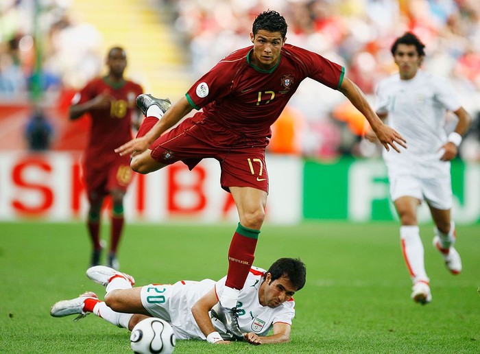 FRANKFURT, GERMANY - JUNE 17: Cristiano Ronaldo of Portugal hurdles the challenge of Mohammad Nosrati of Iran during the FIFA World Cup Germany 2006 Group D match between Portugal and Iran played at the Stadium Frankfurt on June 17, 2006 in Frankfurt, Germany. (Photo by Clive Mason/Getty Images)