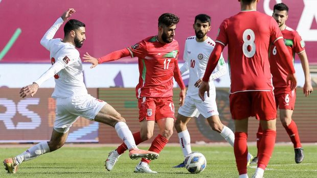 Iran's midfielder Ali Gholizadeh (C) is marked by Lebanon's midfielder Mohammed Dhaini (L) during the 2022 Qatar World Cup Asian Qualifiers football match between Iran and Lebanon, at the Imam Reza Stadium in the city of Mashhad, on March 29, 2022. (Photo by Farshad ABBASI / AFP)