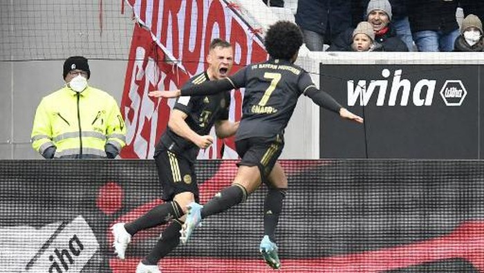 Bayern Munichs German midfielder Serge Gnabry (R) celebrates scoring the 2-1 goal with Bayern Munichs German midfielder Joshua Kimmich during the German first division Bundesliga football match SC Freiburg v FC Bayern Munich in Freiburg, southern Germany, on April 2, 2022. (Photo by Thomas KIENZLE / AFP) / DFL REGULATIONS PROHIBIT ANY USE OF PHOTOGRAPHS AS IMAGE SEQUENCES AND/OR QUASI-VIDEO