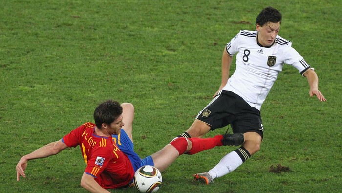 DURBAN, SOUTH AFRICA - JULY 07:  Xabi Alonso of Spain and Mesut Oezil of Germany battle for the ball during the 2010 FIFA World Cup South Africa Semi Final match between Germany and Spain at Durban Stadium on July 7, 2010 in Durban, South Africa.  (Photo by Steve Haag/Getty Images)