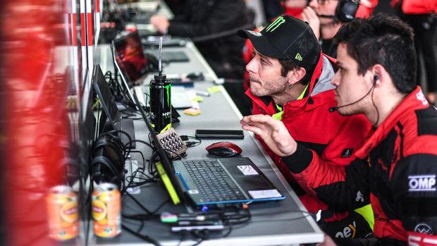 Nine-time MotoGP world champion, Valentino Rossi (C) works with a technician during the Fanatec GT World Challenge Europe 2022 on April 03, 2022 at the Imola race track, Italy. - Rossi has signed with Belgian team Wrt and will race an Audi R8 Lms, bearing the unmistakable number 46 in the Fanatec Challenge Europe championship. (Photo by Andrea SCIARRA / AFP)