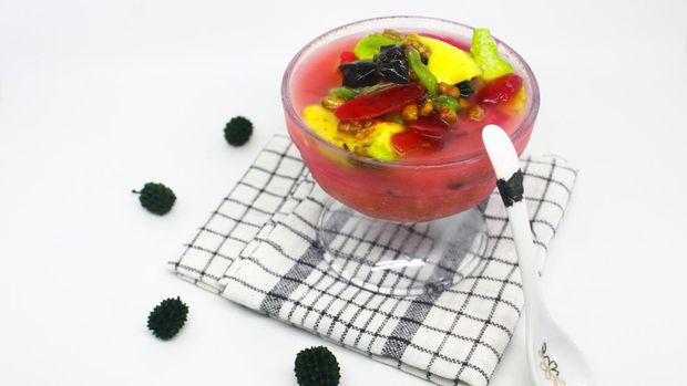 Es Campur. Iced dessert drink made of mixed fruits, jelly and milk and strawberry syrup