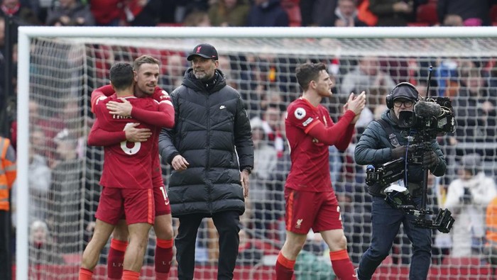 Liverpools manager Jurgen Klopp, smiles as his players celebrate after winning the English Premier League soccer match between Liverpool and Watford at Anfield stadium in Liverpool, England, Saturday, April 2, 2022. (AP Photo/Jon Super)