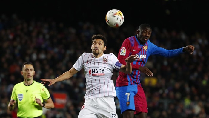 Barcelonas Ousmane Dembele, right, and Sevillas Jesus Navas challenge for the ball during the Spanish La Liga soccer match between FC Barcelona and Sevilla at the Camp Nou stadium in Barcelona, Spain, Sunday, April 3, 2022. (AP Photo/Joan Monfort)