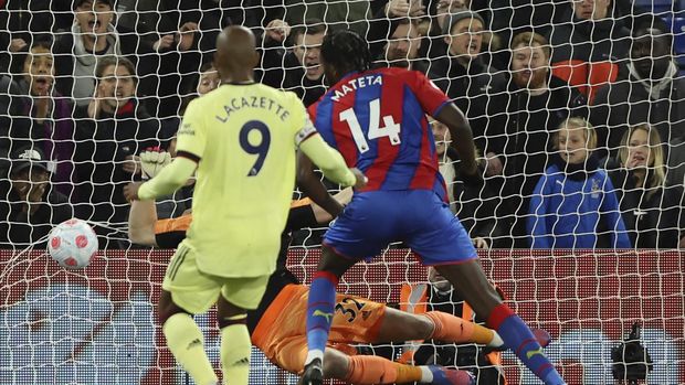 Crystal Palace's Jean-Philippe Mateta, center, scores the opening goal past Arsenal's goalkeeper Aaron Ramsdale during the English Premier League soccer match between Crystal Palace and Arsenal at Selhurst Park stadium in London, England, Monday, April 4, 2022. (AP Photo/Ian Walton)
