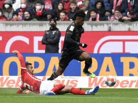 Bayern Munich's French forward Kingsley Coman (top) vies for the ball with Freiburg's German defender Manuel Gulde (R) during the German first division Bundesliga football match SC Freiburg v FC Bayern Munich in Freiburg, southern Germany, on April 2, 2022. (Photo by Thomas KIENZLE / AFP) / DFL REGULATIONS PROHIBIT ANY USE OF PHOTOGRAPHS AS IMAGE SEQUENCES AND/OR QUASI-VIDEO