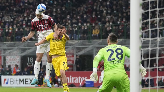 AC Milans Zlatan Ibrahimovic, left, and Bolognas Denso Kasius jump for the ball during the Serie A soccer match between AC Milan and Bologna at the San Siro stadium, in Milan, Italy, Monday, April 4, 2022. (AP Photo/Antonio Calanni)