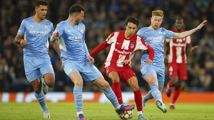 Atletico Madrids Joao Felix, second right, is challenged by Manchester Citys Aymeric Laporte, second left, Manchester Citys Kevin De Bruyne, right, and Manchester Citys Rodrigo, left, during the Champions League, first leg, quarterfinal soccer match between Manchester City and Atletico Madrid at the Etihad Stadium, in Manchester, Tuesday, April 5, 2022. (AP Photo/Dave Thompson)