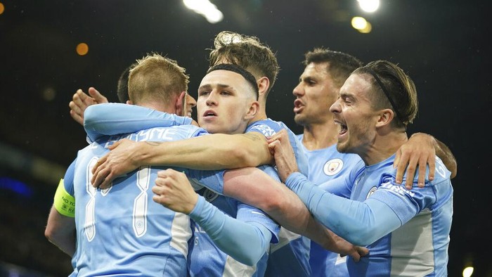 Atletico Madrids Marcos Llorente, left, fights for the ball with Manchester Citys Rodrigo during the Champions League, first leg, quarterfinal soccer match between Manchester City and Atletico Madrid at the Etihad Stadium, in Manchester, Tuesday, April 5, 2022. (AP Photo/Dave Thompson)