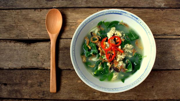 ilustrasi sayur daun katuk Egg soup with vegetables Asian Style on wooden background