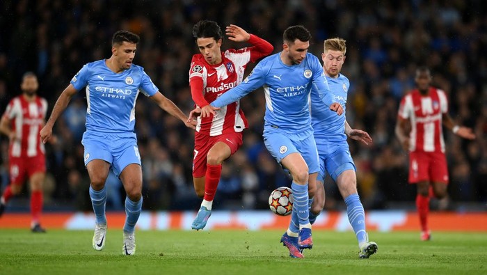 MANCHESTER, ENGLAND - APRIL 05: Joao Felix of Atletico Madrid is challenged by Rodrigo, Aymeric Laporte and Kevin De Bruyne of Manchester City  during the UEFA Champions League Quarter Final Leg One match between Manchester City and Atletico Madrid at City of Manchester Stadium on April 05, 2022 in Manchester, England. (Photo by Michael Regan/Getty Images)