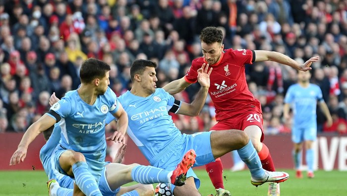 LIVERPOOL, ENGLAND - OCTOBER 03: Diogo Jota of Liverpool cuts back whilst under pressure from Aymeric Laporte, Ruben Dias and Joao Cancelo of Manchester City during the Premier League match between Liverpool and Manchester City at Anfield on October 03, 2021 in Liverpool, England. (Photo by Michael Regan/Getty Images)
