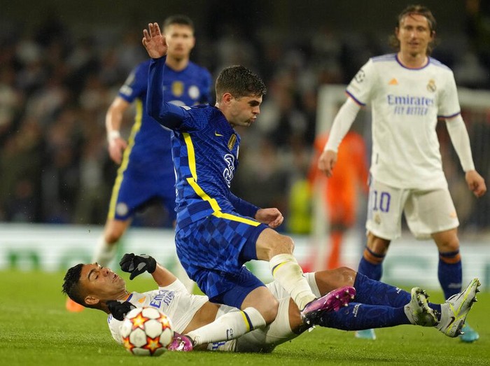Chelsea's Christian Pulisic, right, is tackled by Real Madrid's Casemiro during a Champions League first-leg quarterfinal soccer match between Chelsea and Real Madrid at Stamford Bridge stadium in London, Wednesday, April 6, 2022. (AP Photo/Kirsty Wigglesworth)