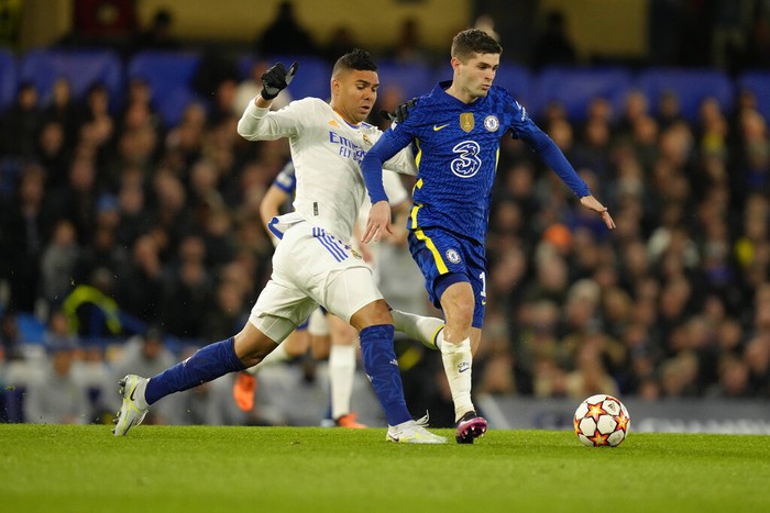 Chelseas Christian Pulisic, right, challenges for the ball with Real Madrids Casemiro during a Champions League first-leg quarterfinal soccer match between Chelsea and Real Madrid at Stamford Bridge stadium in London Wednesday, April 6, 2022. (AP Photo/Kirsty Wigglesworth)