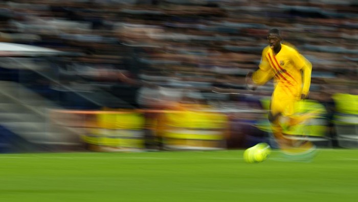 In this photo taken with slow shutter speed, Barcelonas Ousmane Dembele runs with the ball during a Spanish La Liga soccer match between Rial Madrid and FC Barcelona at the Santiago Bernabeu stadium in Madrid, Spain, Sunday, March 20, 2022. (AP Photo/Manu Fernandez)