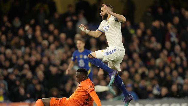 Real Madrid's Karim Benzema, right, scores his side's third goal past by Chelsea's goalkeeper Edouard Mendy during a Champions League first-leg quarterfinal soccer match between Chelsea and Real Madrid at Stamford Bridge stadium in London, Wednesday, April 6, 2022. (AP Photo/Kirsty Wigglesworth)