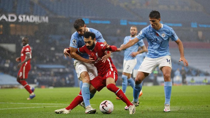 MANCHESTER, ENGLAND - NOVEMBER 08: Mohamed Salah of Liverpool holds off Ruben Dias and Rodrigo of Manchester City during the Premier League match between Manchester City and Liverpool at Etihad Stadium on November 08, 2020 in Manchester, England. Sporting stadiums around the UK remain under strict restrictions due to the Coronavirus Pandemic as Government social distancing laws prohibit fans inside venues resulting in games being played behind closed doors. (Photo by Clive Brunskill/Getty Images)